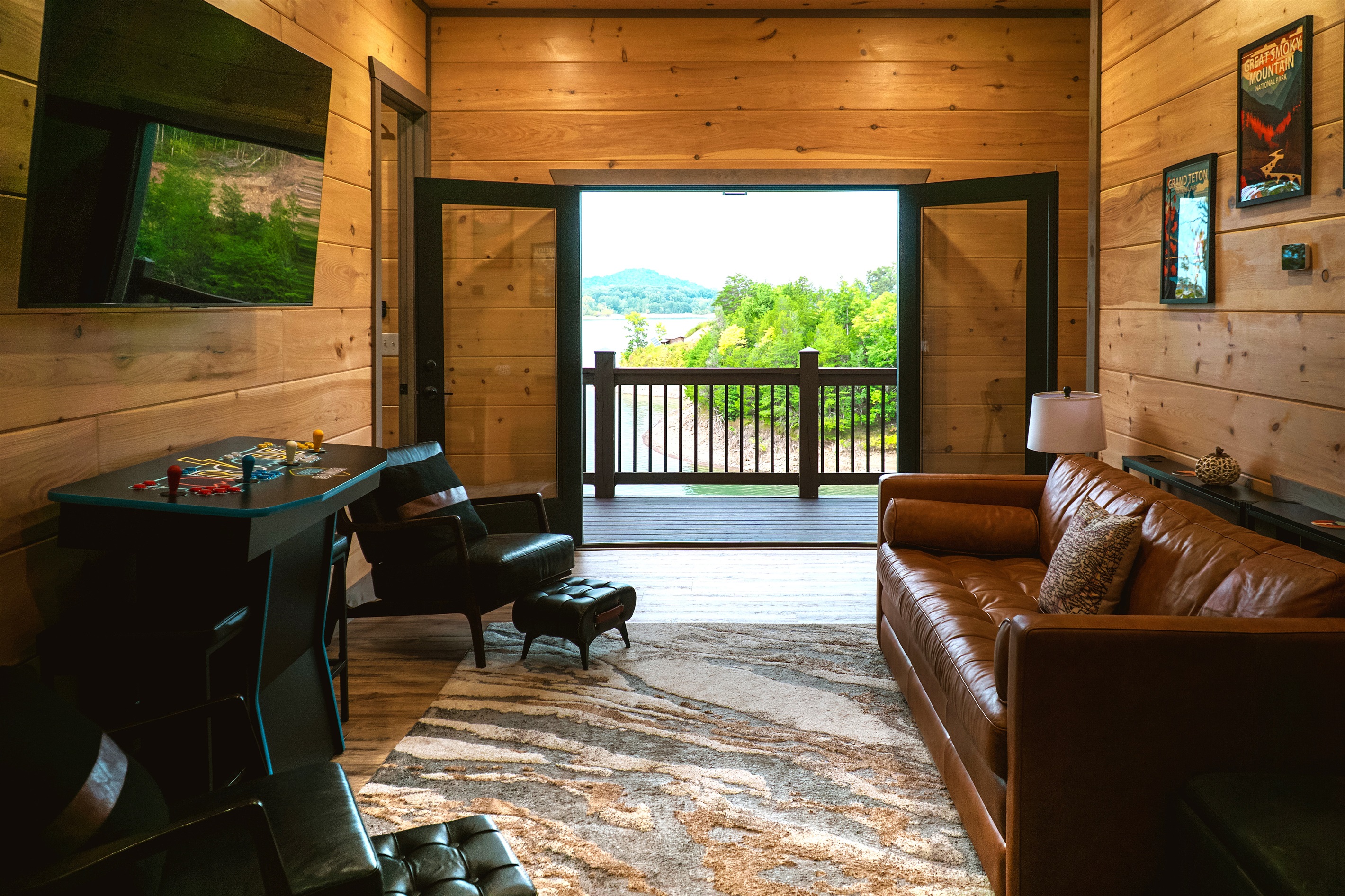 Mid-level family room with queen sleeper sofa, arcade game (upgraded since photo), karaoke, board games and books.  Don't forget the deck with epic views and two large captain chairs perfect for ready or just relaxing and soaking in the view!