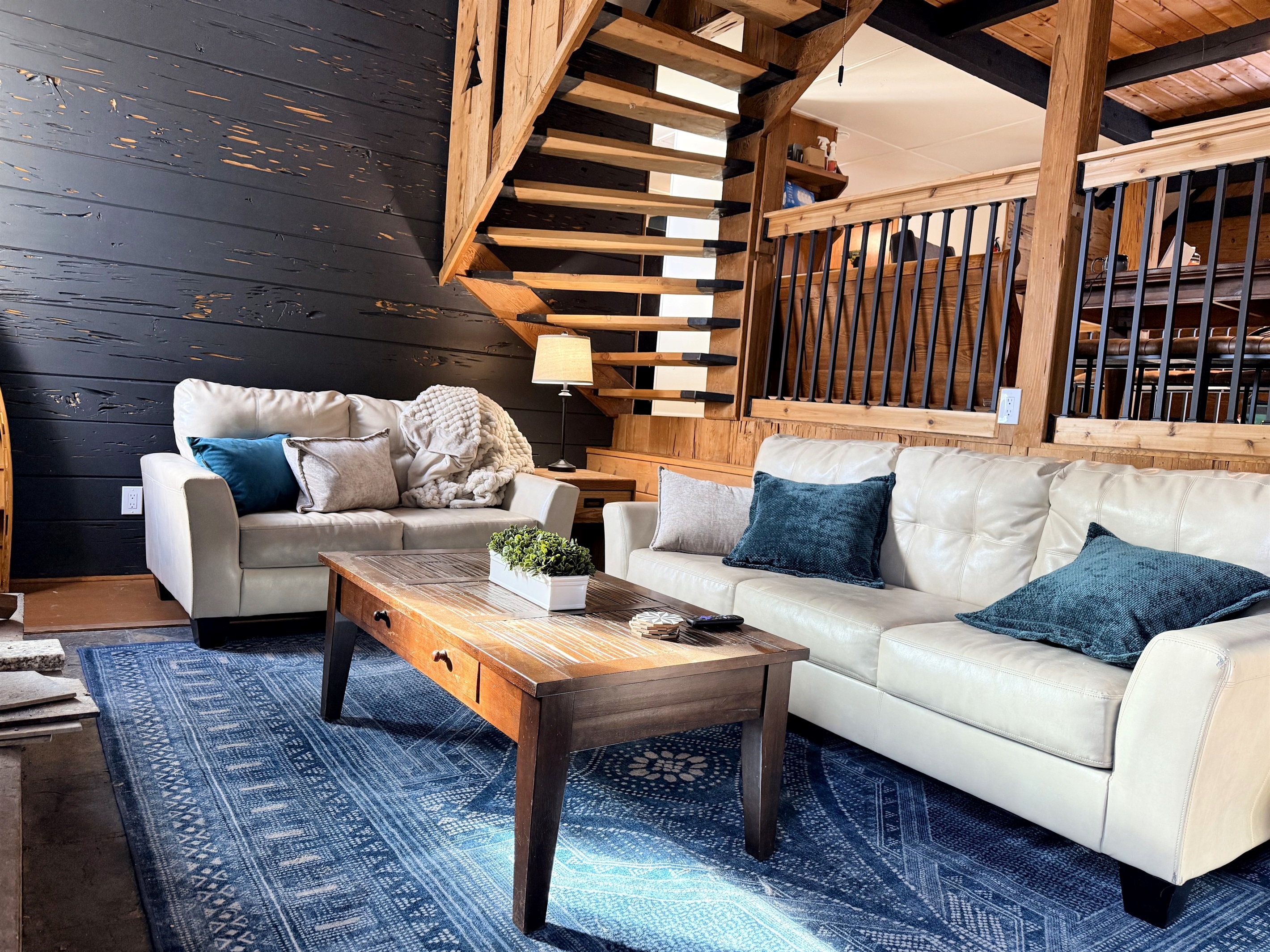 Unwind in your cozy living room with plush seating next to a crackling fire in the stone fireplace. Soft throws and a rustic wood coffee table—perfect for game nights, reading, or relaxing by the warmth of the cabin charm.