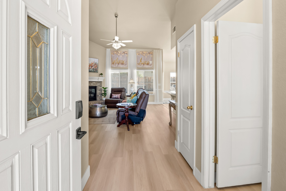 Step inside and feel right at home. The bright, welcoming entryway opens into a spacious living area with soaring ceilings, abundant natural light, and comfortable furnishings designed for relaxation.