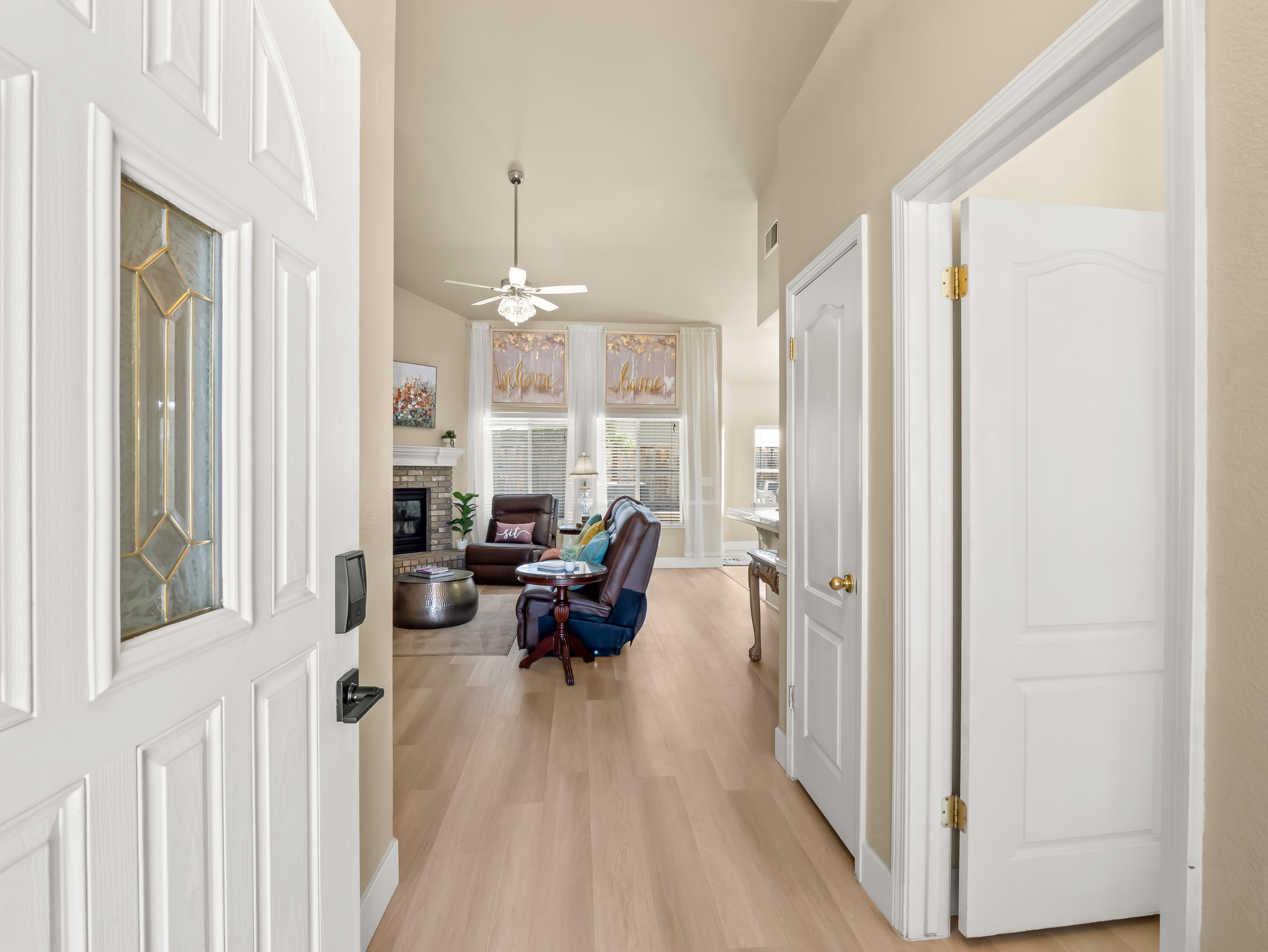 Step inside and feel right at home. The bright, welcoming entryway opens into a spacious living area with soaring ceilings, abundant natural light, and comfortable furnishings designed for relaxation.