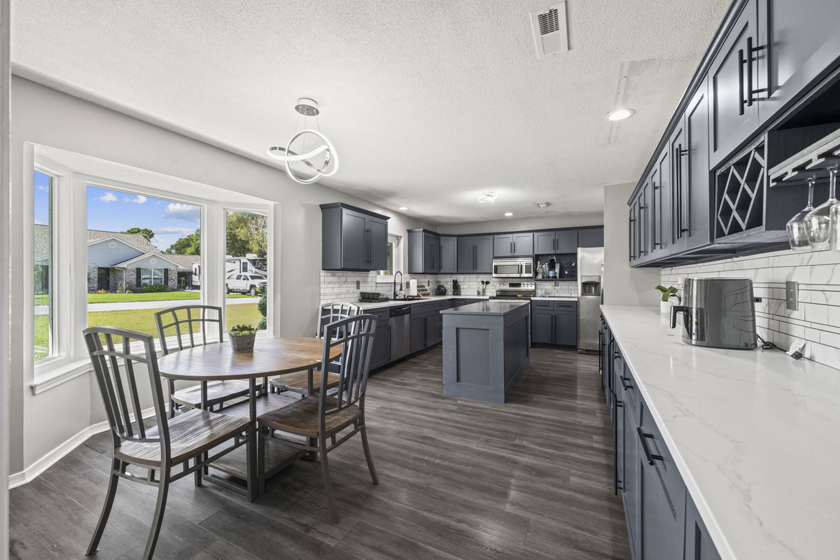 Gather around this cozy breakfast table tucked in a sunlit bay window, with the fully equipped kitchen just steps away.