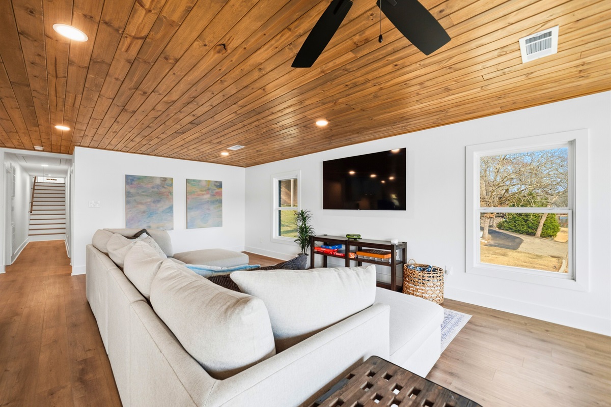 With comfortable sectional seating and a warm wood ceiling overhead, this inviting space is ideal for relaxing evenings and easy time together.