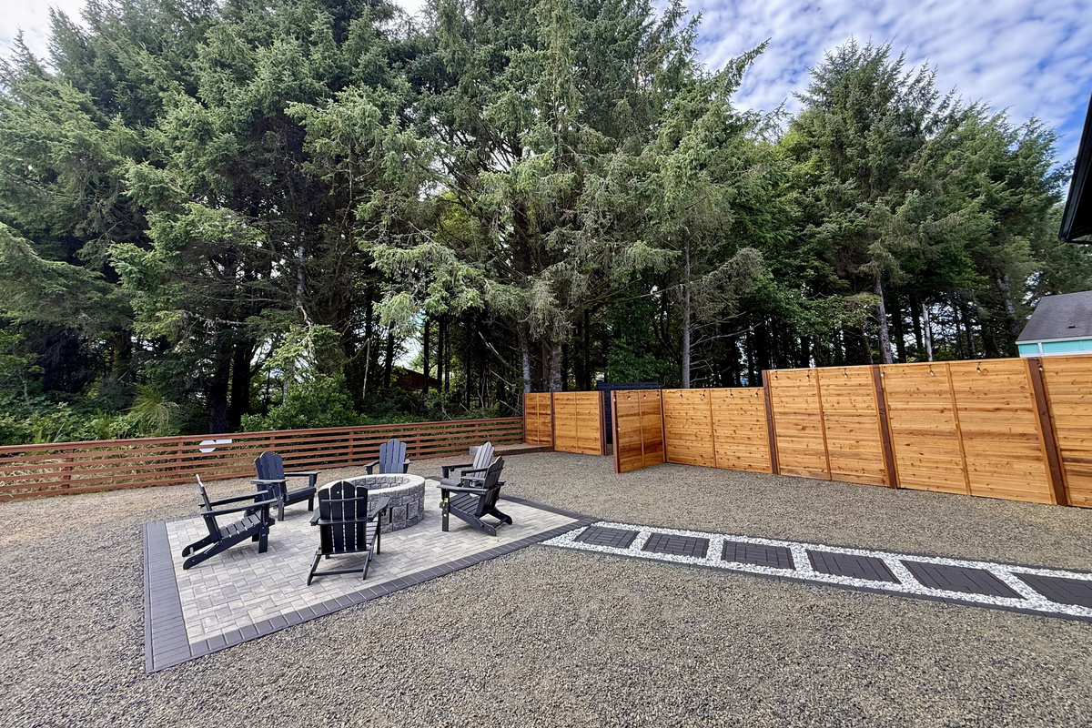 Pull up one of the six Adirondack chairs around the fire pit — the paver patio out back is where the day winds down, tucked in behind the cedar fence.