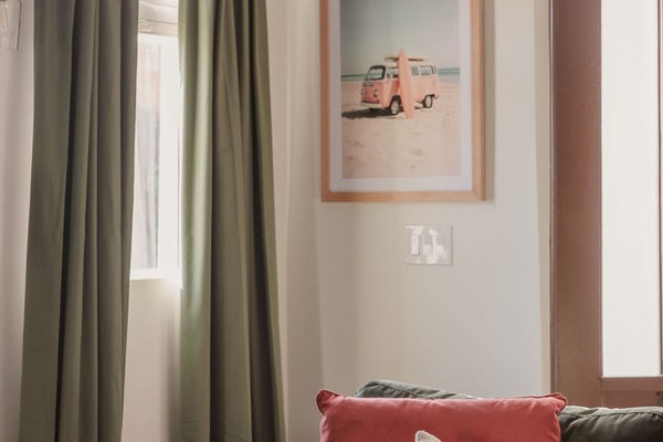 That SoCal feeling, captured in a corner. Sun-drenched curtains, a hint of ocean breeze, and beachy artwork that reminds you: you're on vacation.