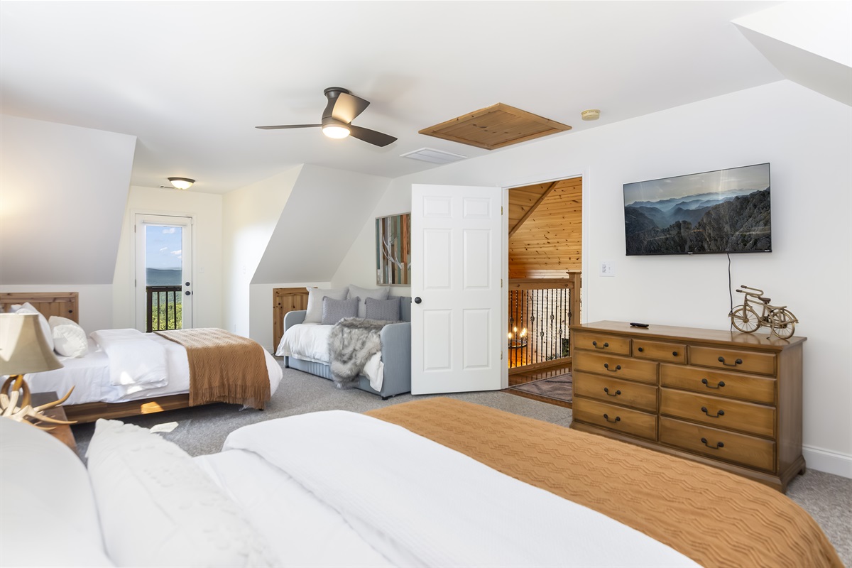 Bedroom w/ 2 queen beds, twin, dresser, and TV