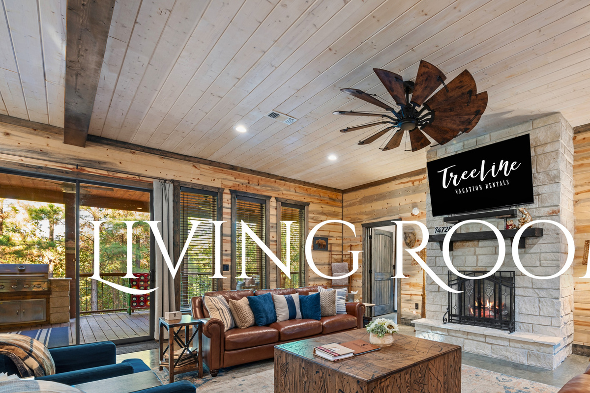The living room invites you to kick back and relax with cozy seating and beautiful views of the surrounding forest.