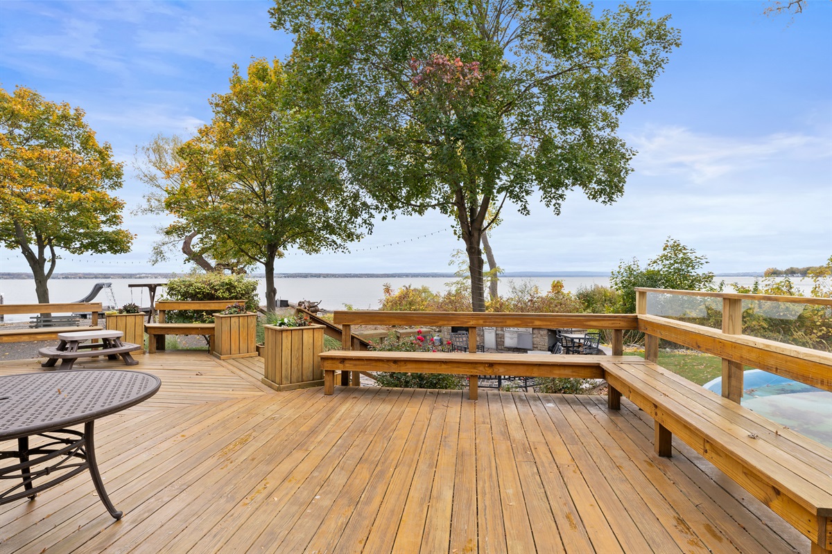 Expansive deck with seating for family gatherings and lakefront dinners.