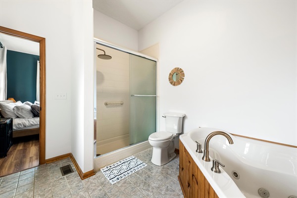 Light-filled ensuite bath with soaking tub and walk-in shower—perfect for unwinding after a day in the mountains.  Grab rail in shower for added safety.