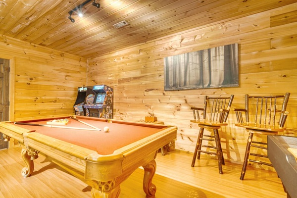 Game room with pool table, shuffle board, arcade games, and 50" smart tv