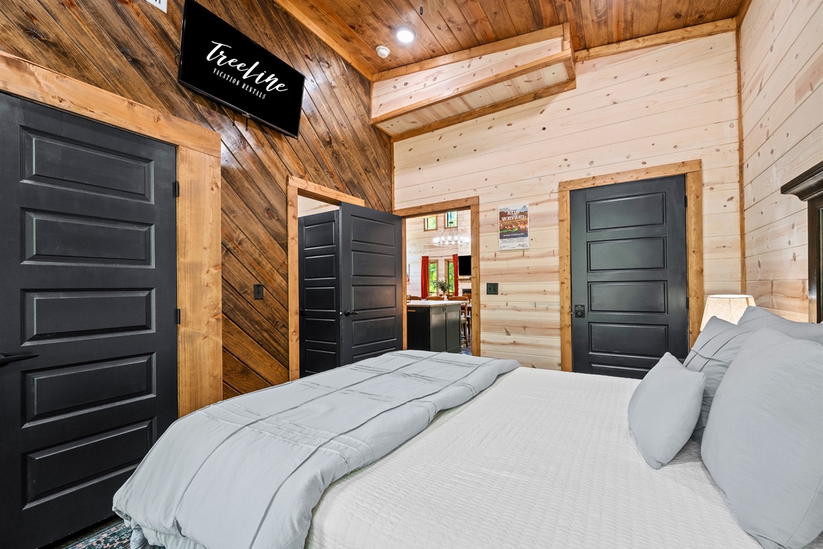 Bedroom 2 features a mounted TV, closet space, and rustic details.