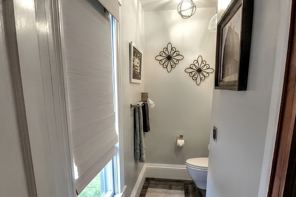 "Hirs" half bathroom has a large window with blackout shade