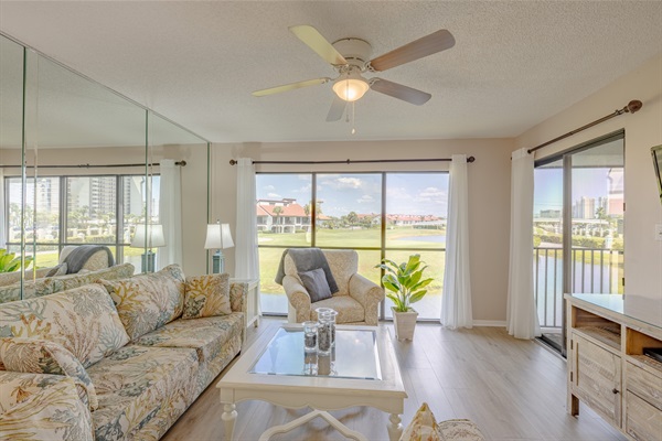 Living area has a ceiling fan, couches and smart TV