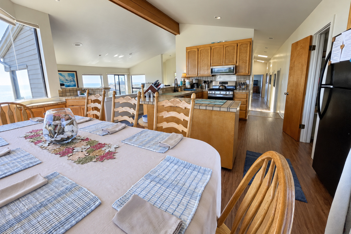 Dining table facing kitchen and bdrm hallways