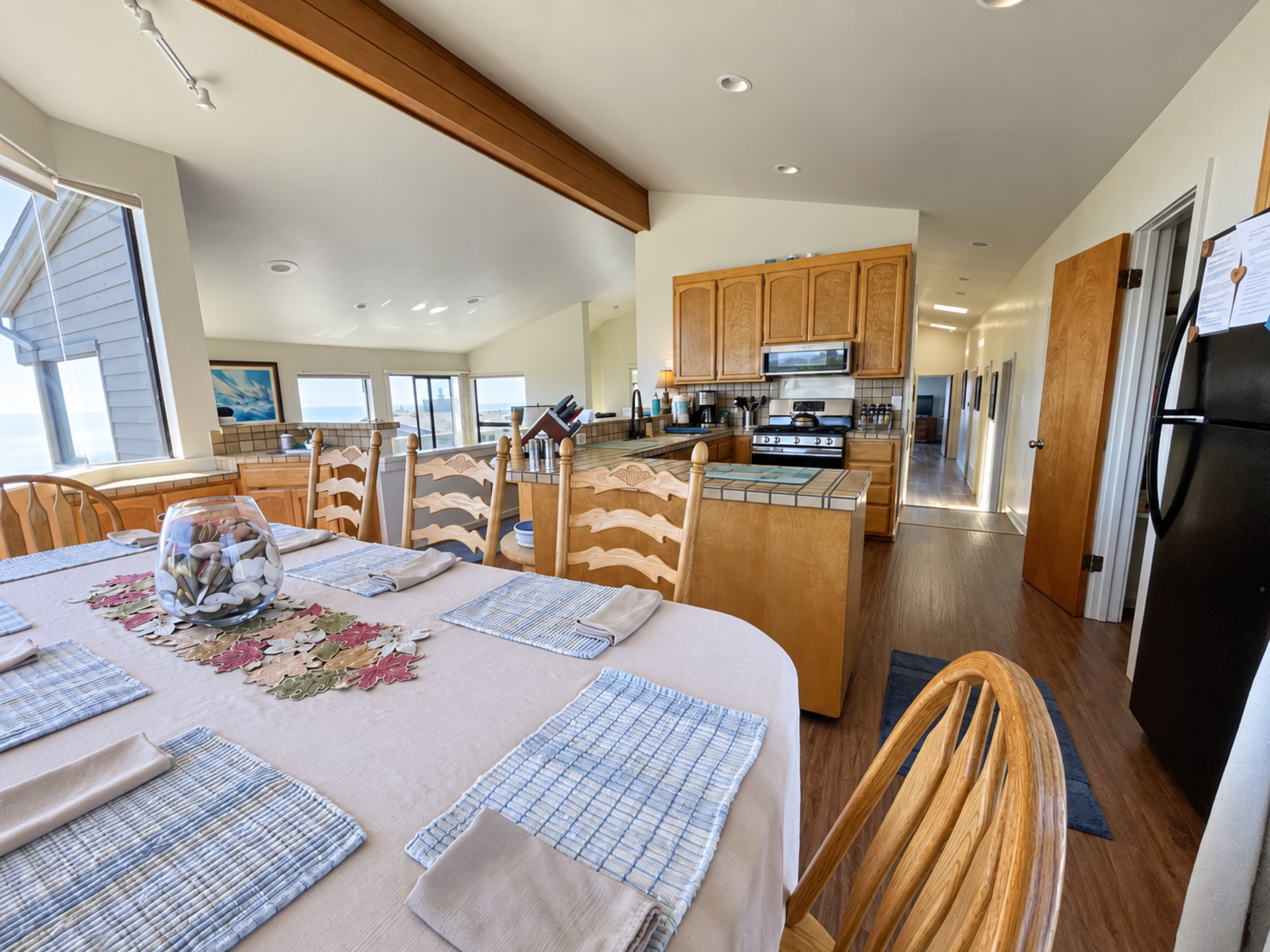 Dining table facing kitchen and bdrm hallways