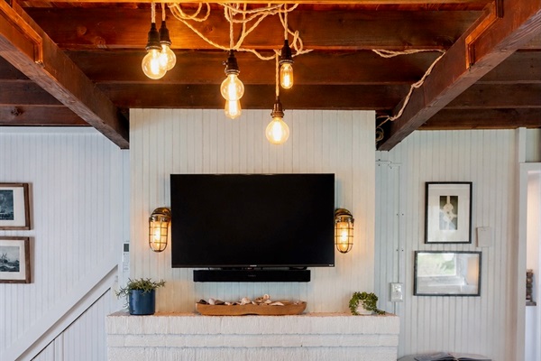 Beadboard-lined walls and exposed beams bring cozy cottage charm to this inviting living room, complete with a smart TV for modern comfort.