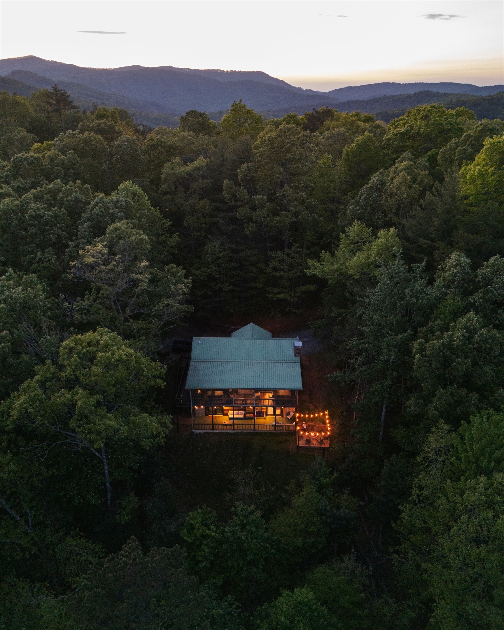 Aerial view of the cabin’s secluded setting, tucked in the trees for privacy, yet just 3 minutes to the Toccoa River and 17 minutes to downtown Blue Ridge. Guests can relax and soak in stunning, year-round scenery from various outdoor spaces, including a s