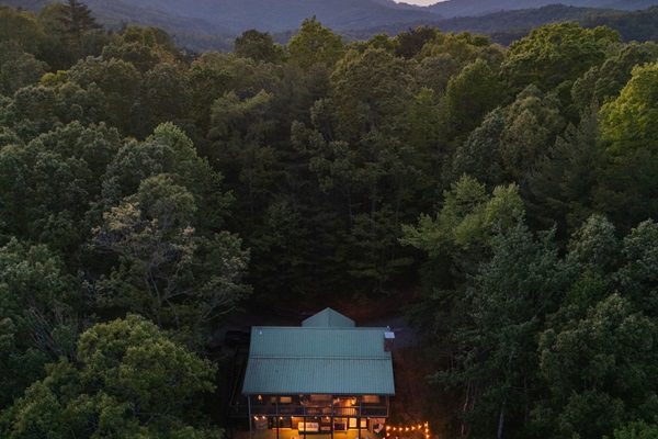 Aerial view of the cabin’s secluded setting, tucked in the trees for privacy, yet just 3 minutes to the Toccoa River and 17 minutes to downtown Blue Ridge. Guests can relax and soak in stunning, year-round scenery from various outdoor spaces, including a s