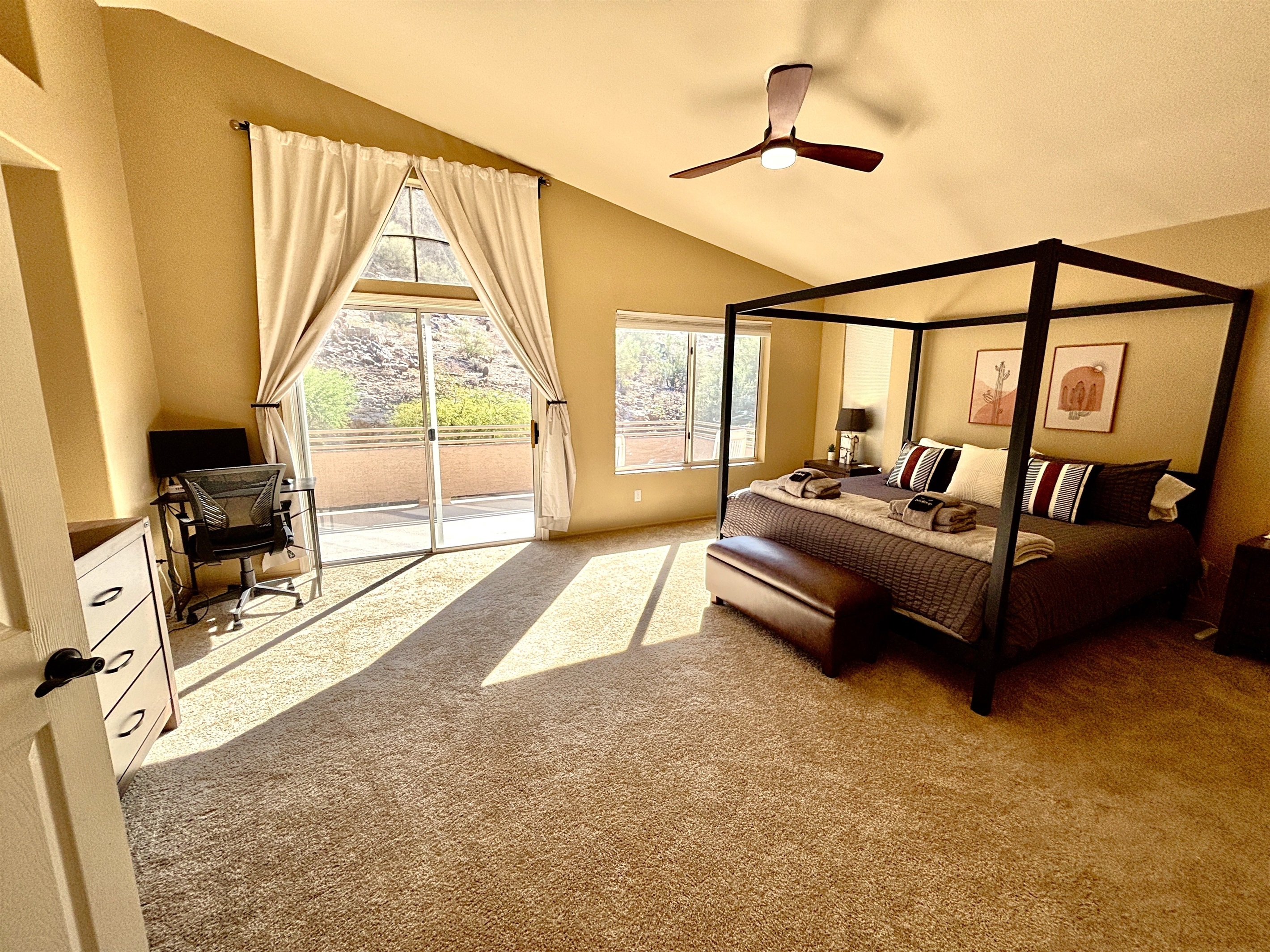 Primary suite with king bed, 55' smart tv, blackout blinds, ceiling fan, remote workstation, walk in closet, ensuite bathroom and private deck