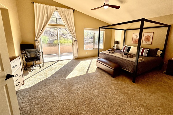 Primary suite with king bed, 55' smart tv, blackout blinds, ceiling fan, remote workstation, walk in closet, ensuite bathroom and private deck