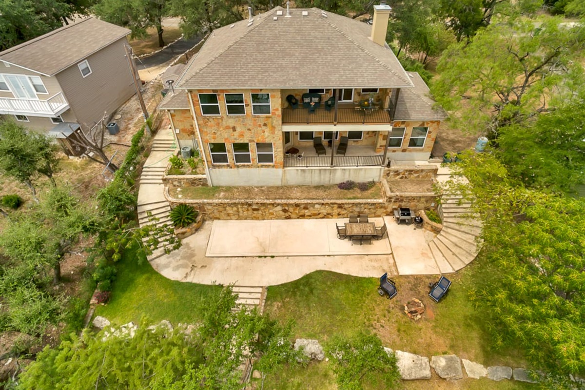 Aerial view of back of home, patio and backyard