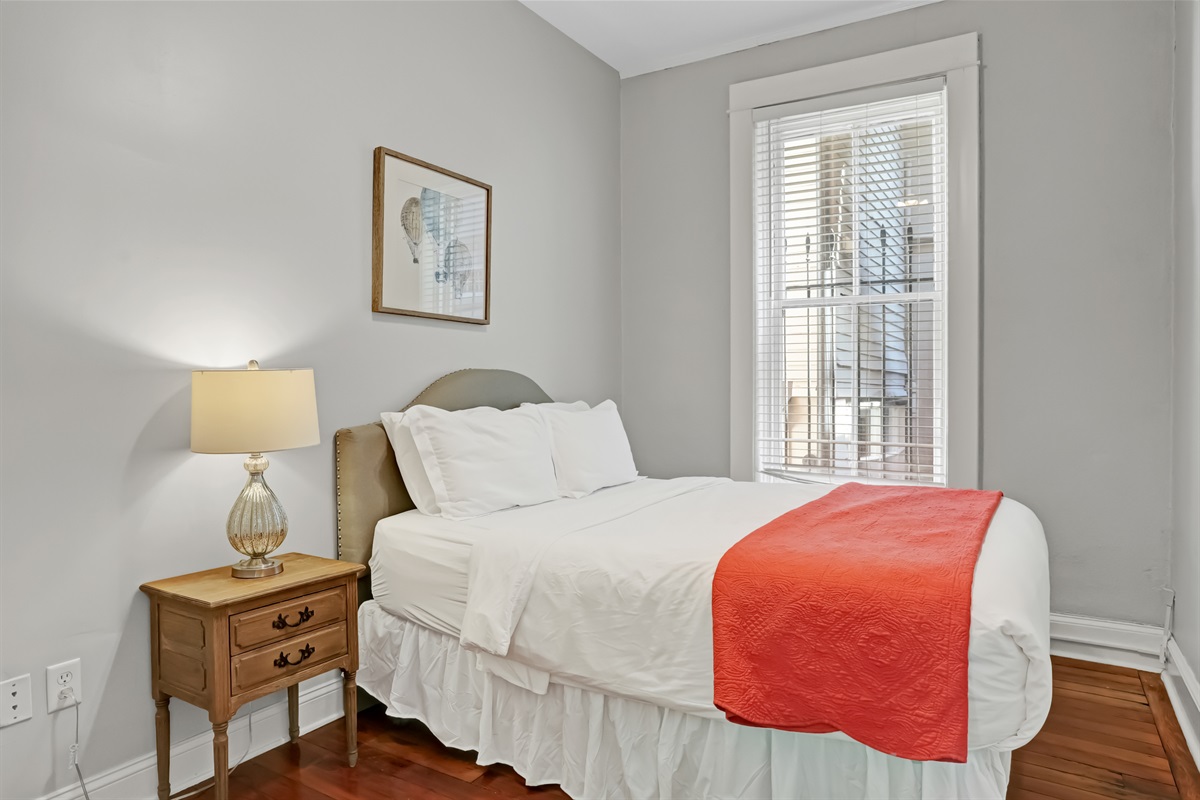 Cozy queen bedroom filled with natural light for a restful stay.
