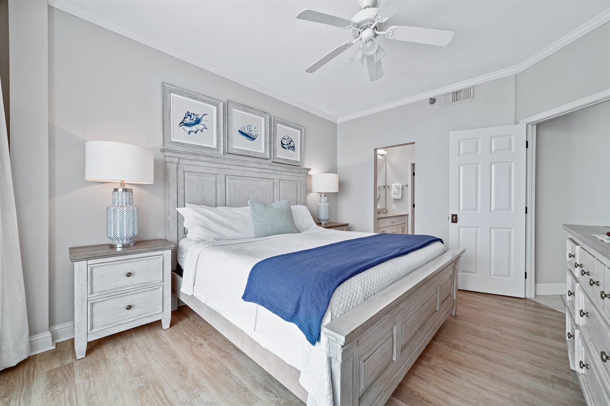 This charming primary bedroom offers a comfortable king-sized bed with vibrant linens, complemented by practical storage solutions. A delightful space to unwind.