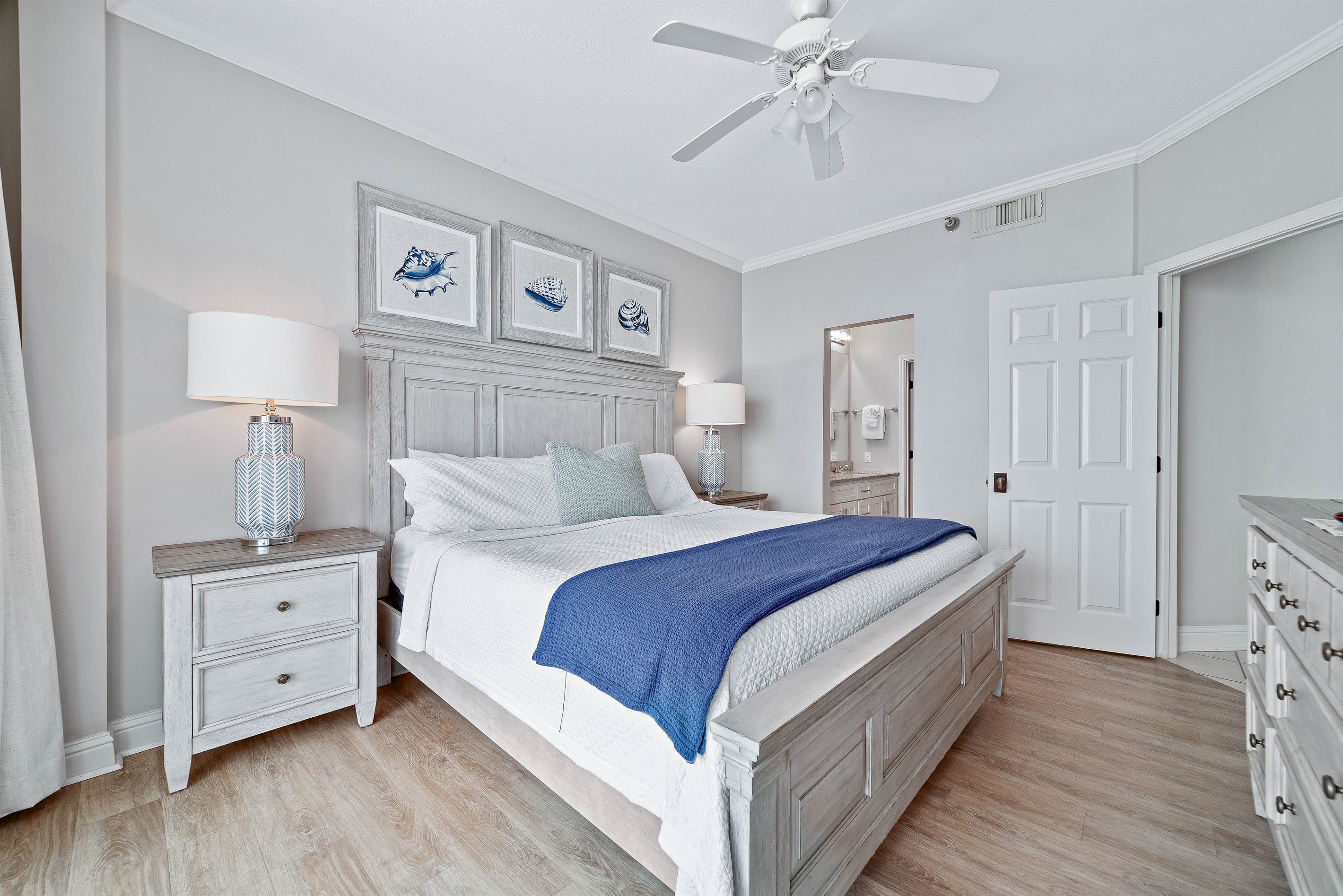 This charming primary bedroom offers a comfortable king-sized bed with vibrant linens, complemented by practical storage solutions. A delightful space to unwind.