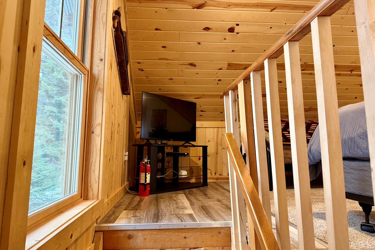 At the top of the stairs, you’ll find a TV for easy upstairs lounging, plus a clearly placed fire extinguisher for peace of mind.