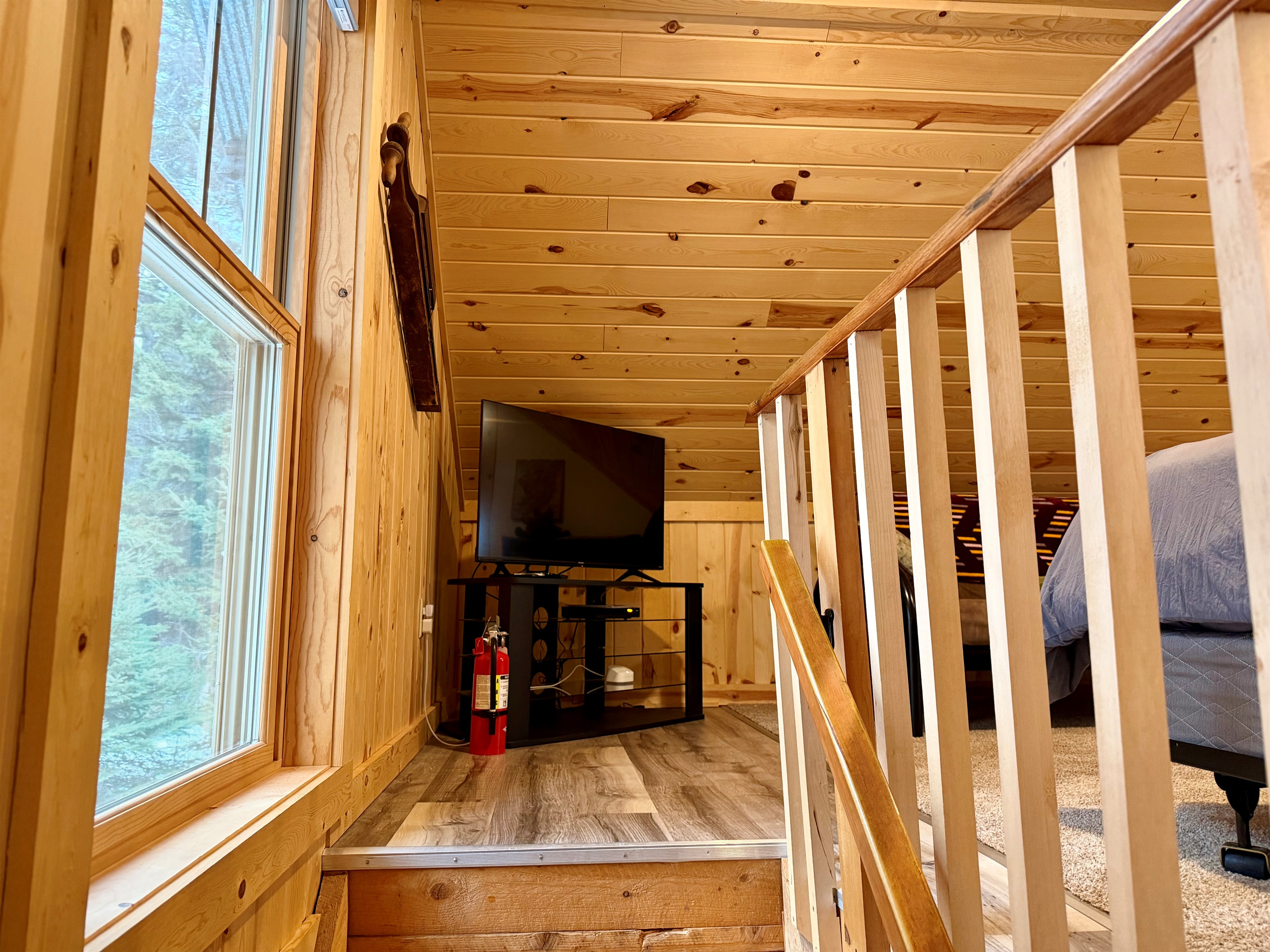 At the top of the stairs, you’ll find a TV for easy upstairs lounging, plus a clearly placed fire extinguisher for peace of mind.