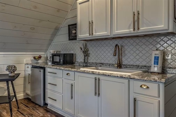 Private kitchenette in the detached guest suite above the garage, complete with a microwave, farmhouse sink, and mini fridge