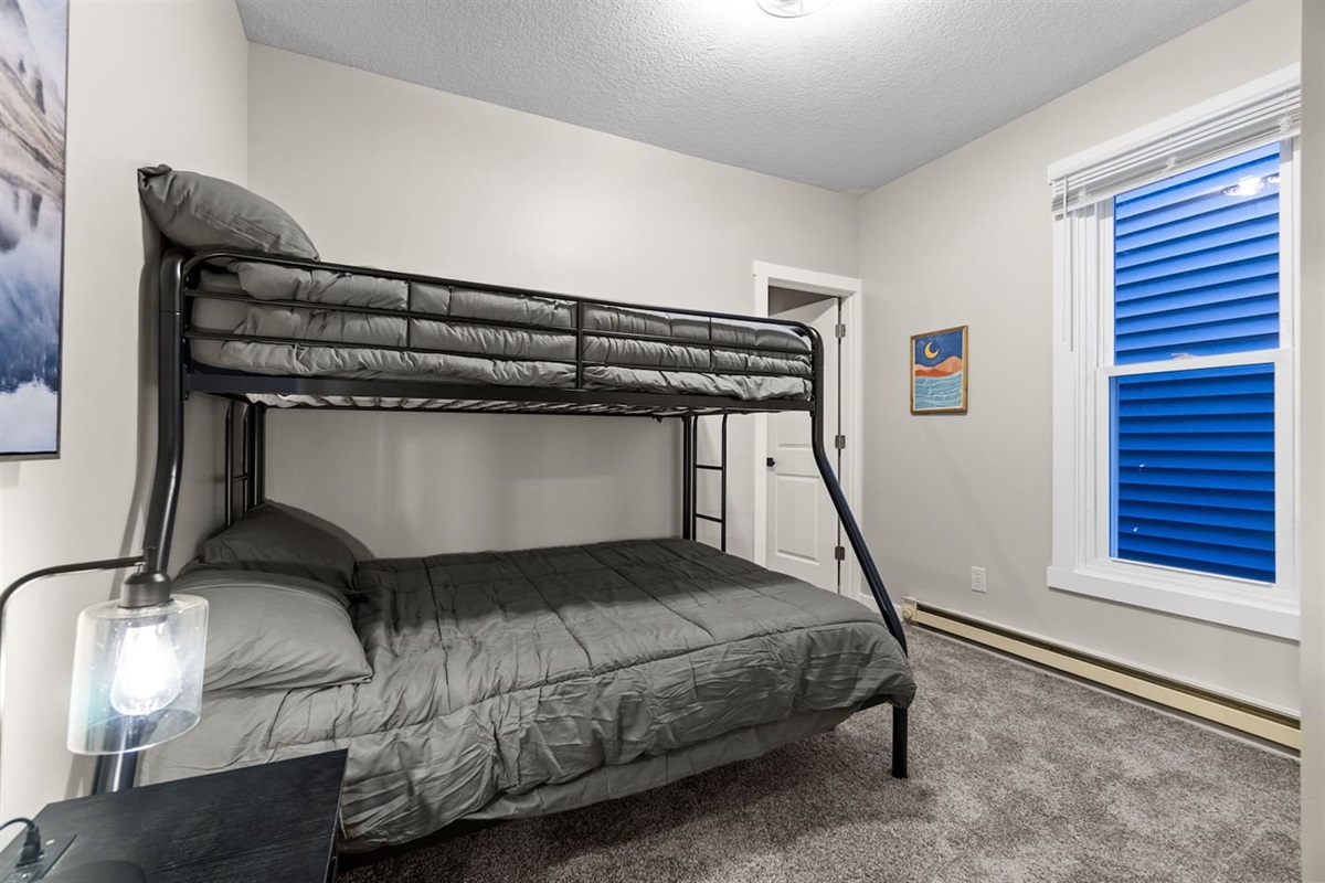 Cozy bunk bed setup with a twin bed on top and a double bed on the bottom, perfect for families or groups.