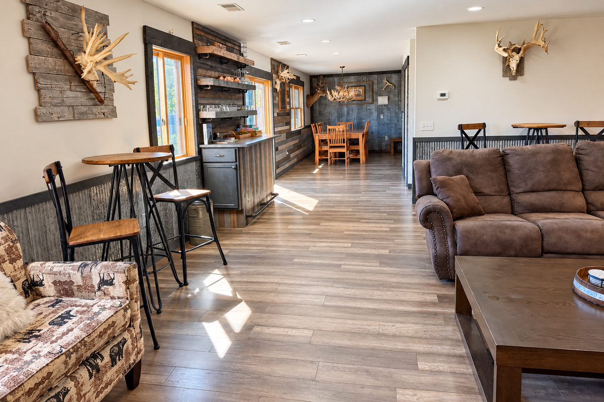 A great view through the lodge’s open gathering spaces, featuring bar-height seating, the dining area, wet bar, and additional seating as you make your way toward the stairs and upper level.