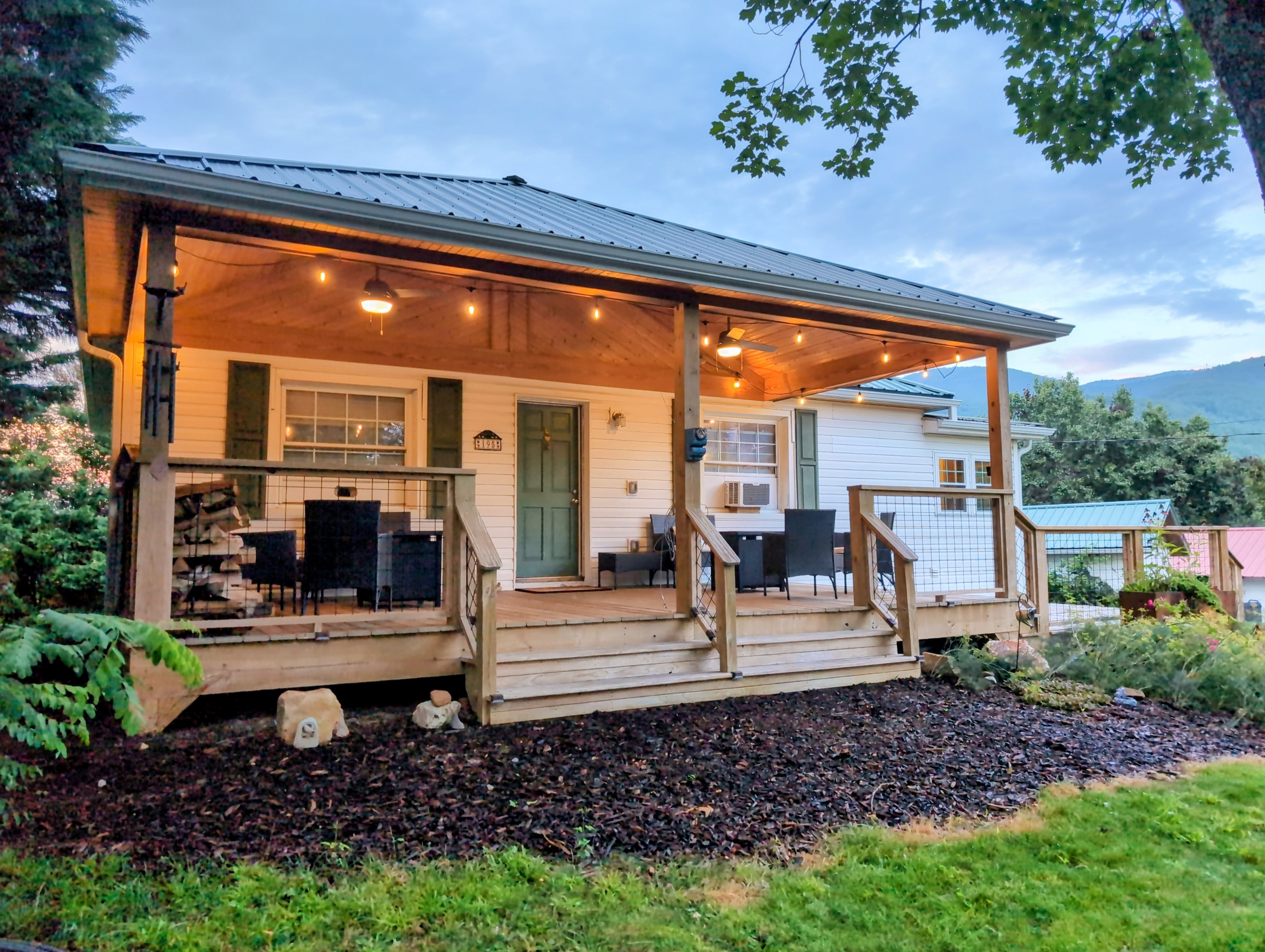 The Bailey Hot Springs — covered porch at dusk with Blue Ridge mountain views"