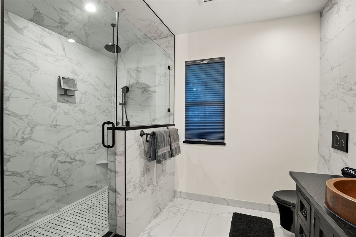 Bathroom with standing shower, toiletries, and bath linens provided