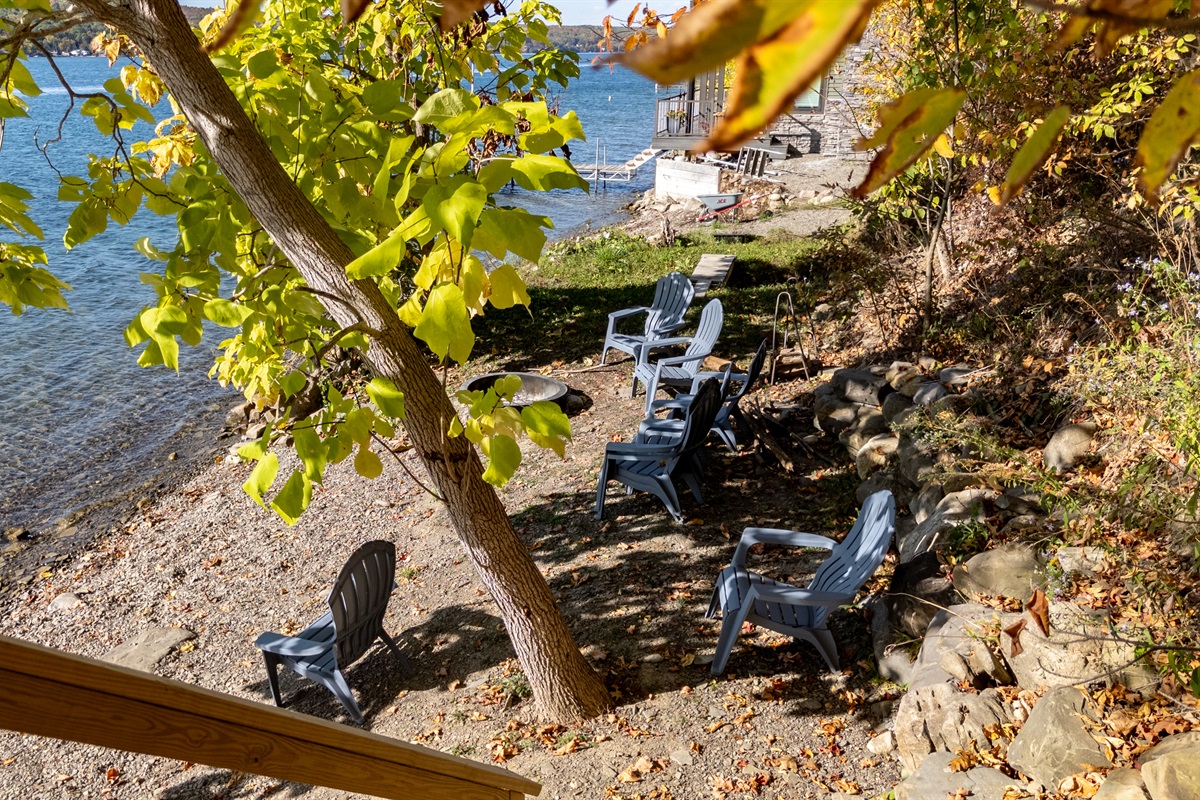 Lakeside chairs and fire-pit area near water’s edge — evening chill zone.