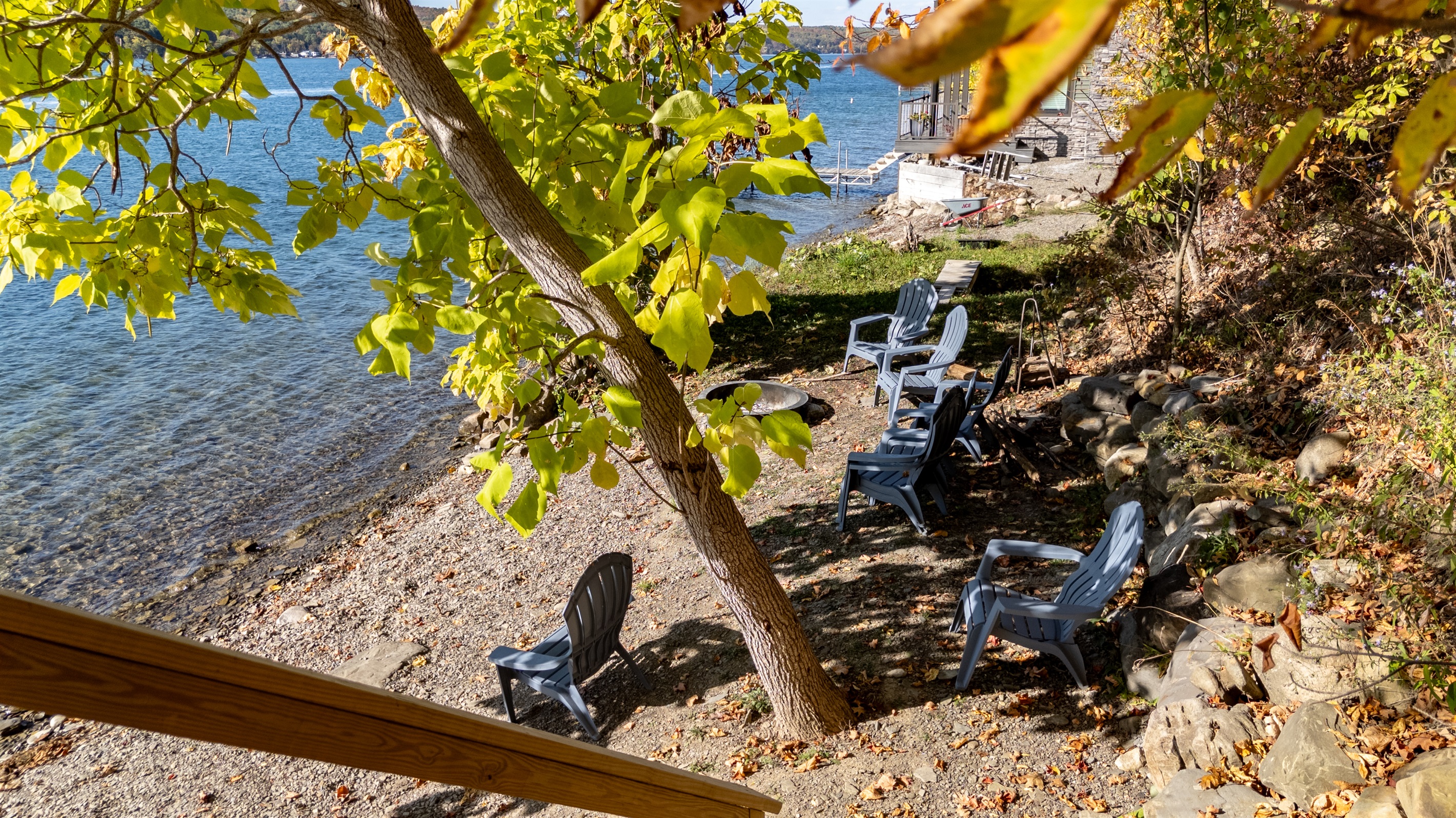 Lakeside chairs and fire-pit area near water’s edge — evening chill zone.