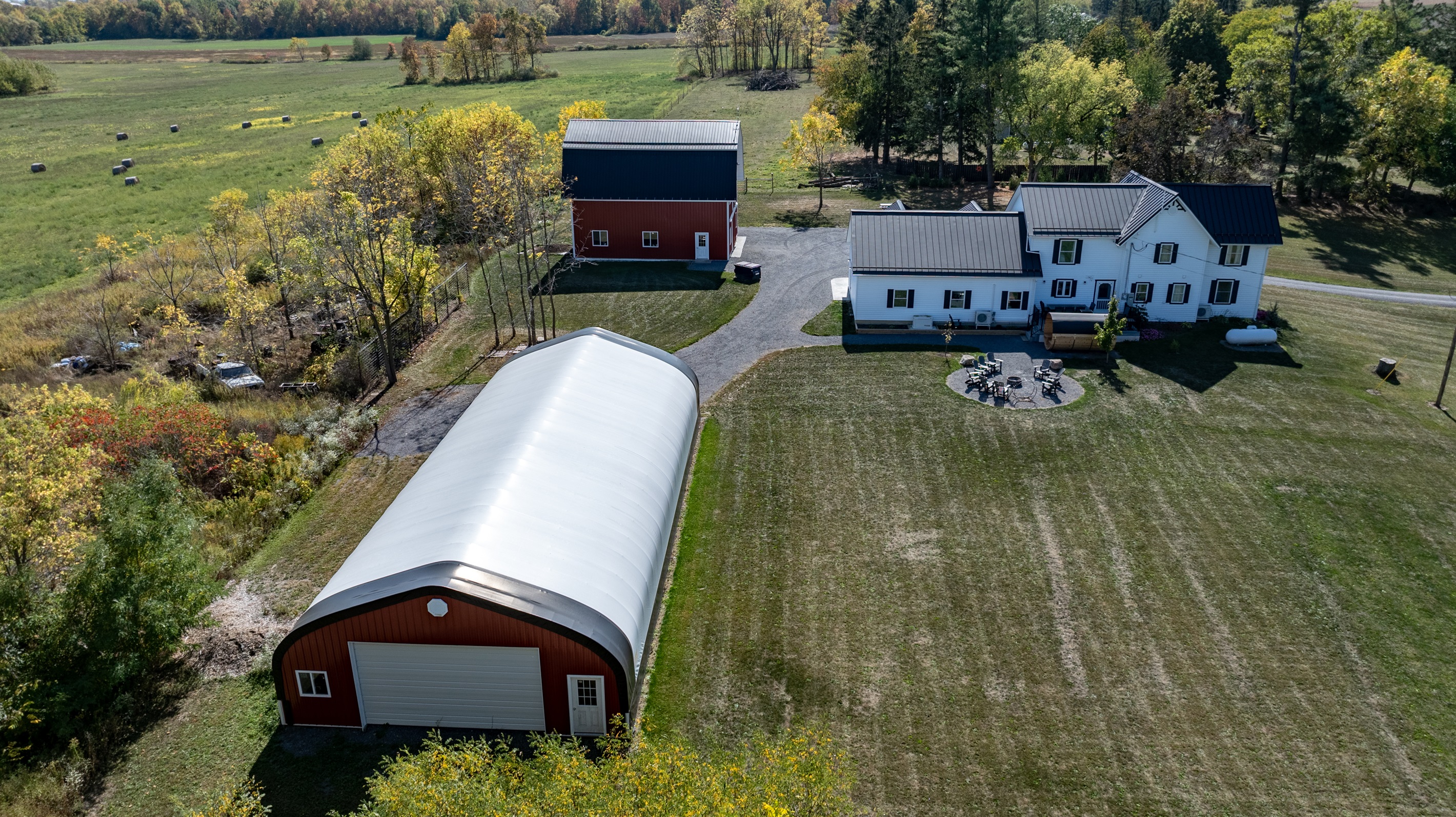 Expansive aerial view of farmhouse and barn — space, privacy, and rustic beauty in every direction