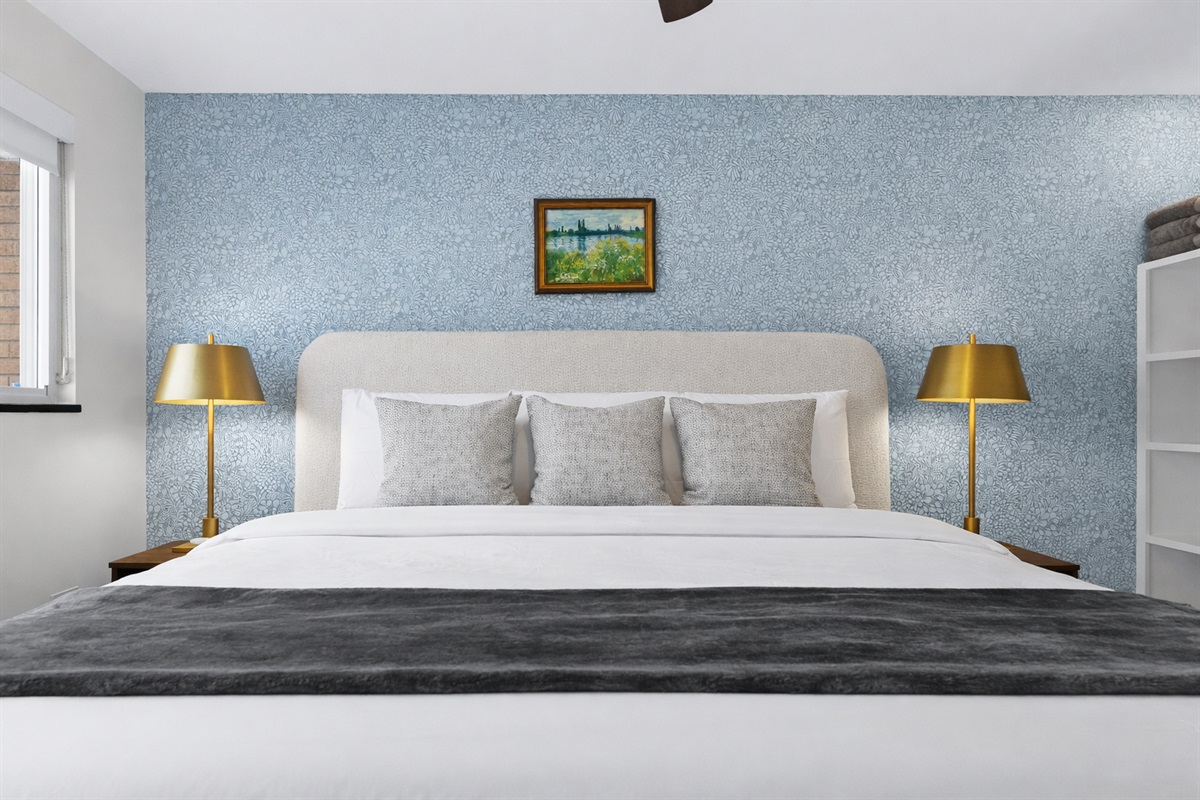 Drift off in this calming bedroom featuring a plush bed, soft linens, elegant lighting, and serene décor—crafted for deep rest and cozy comfort.