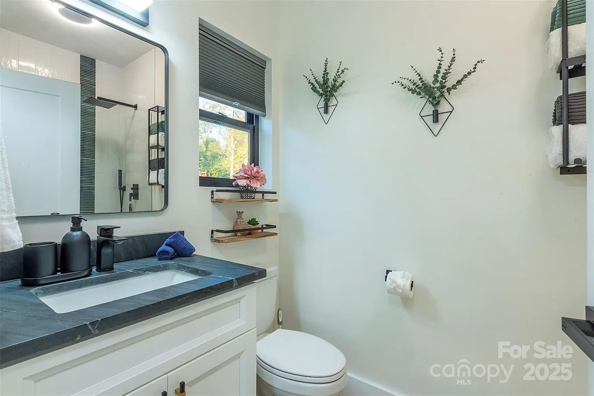Refresh in this modern spa bathroom featuring a sleek black quartz vanity and contemporary matte black fixtures. This bright luxury rental space includes designer accents and plush towels for a true boutique hotel experience.
