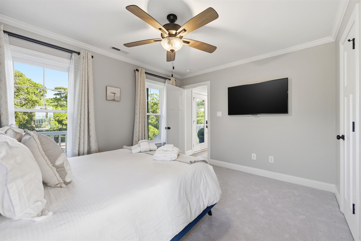Bright and inviting retreat featuring a cozy king bed, natural light, and easy access to the outdoor balcony area