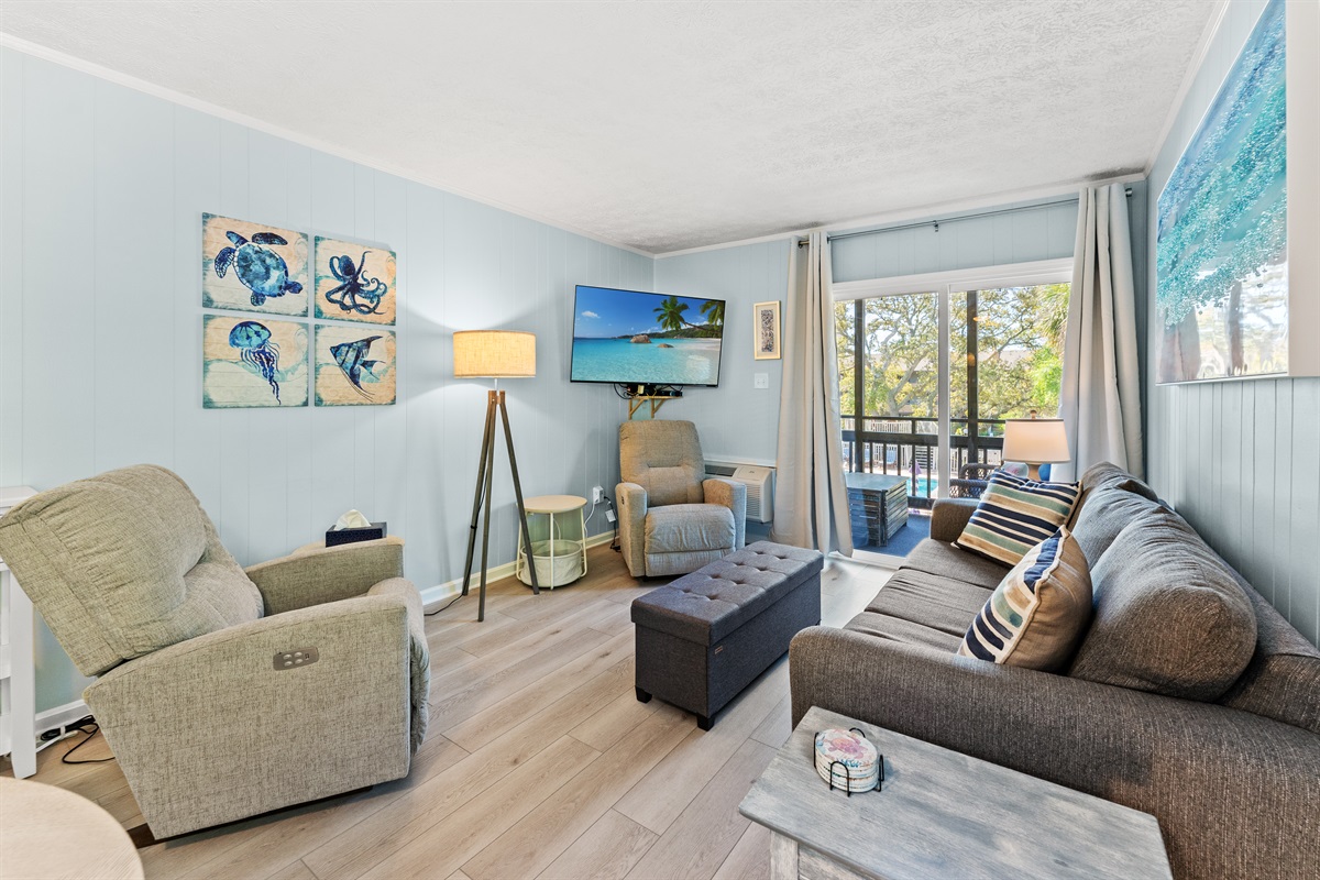 Spacious Living Room area with large TV, sleeper sofa and access to patio.