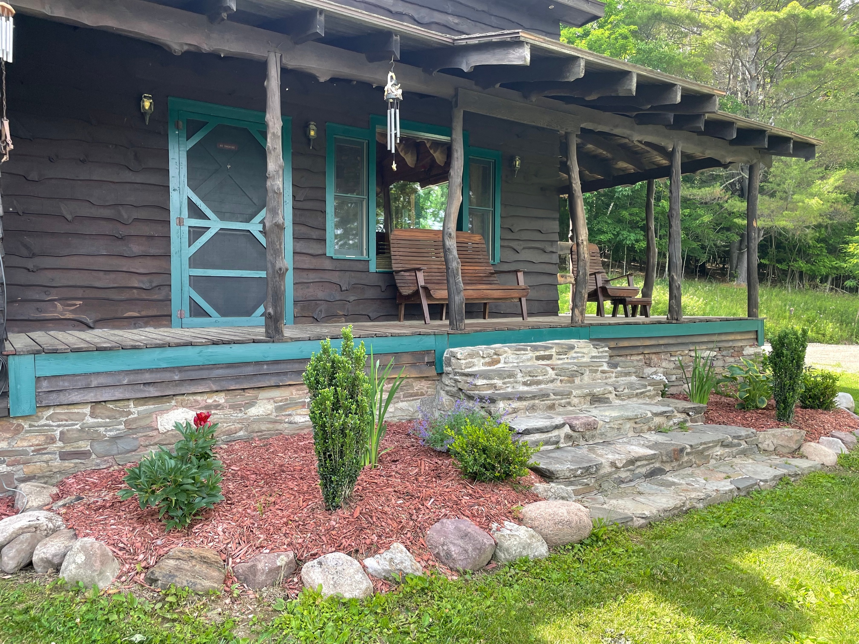 Enjoy the quiet of nature on the covered front porch overlooking the 5 acre private pond.