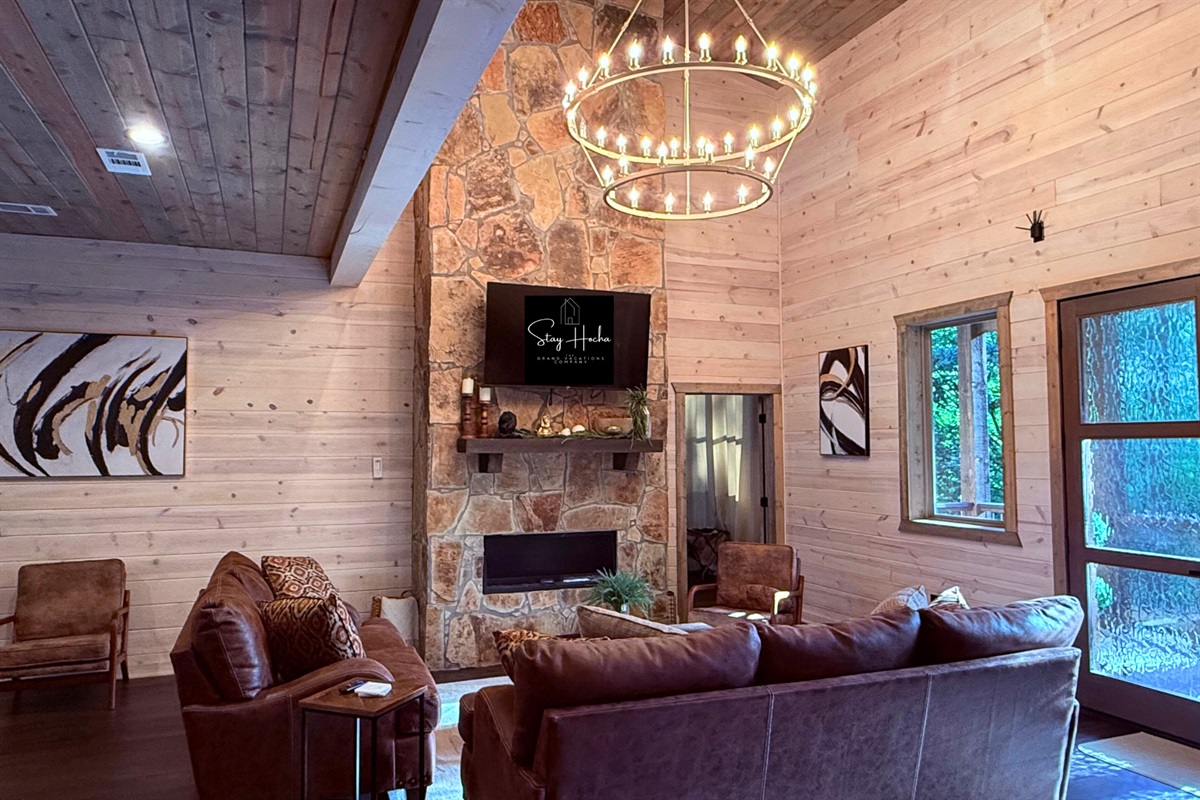 Cozy living room with stone fireplace & nature views