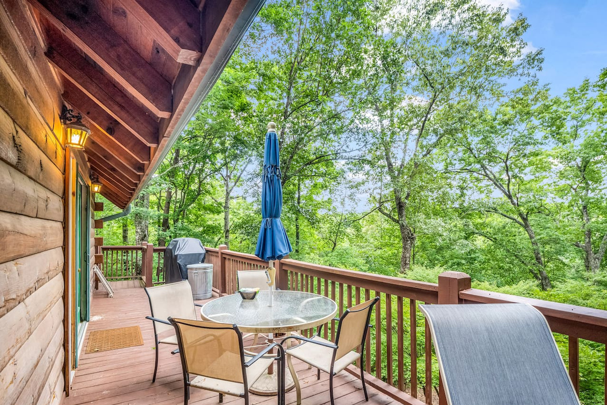 Main level deck with seating area, grill and peaceful woodland scenery