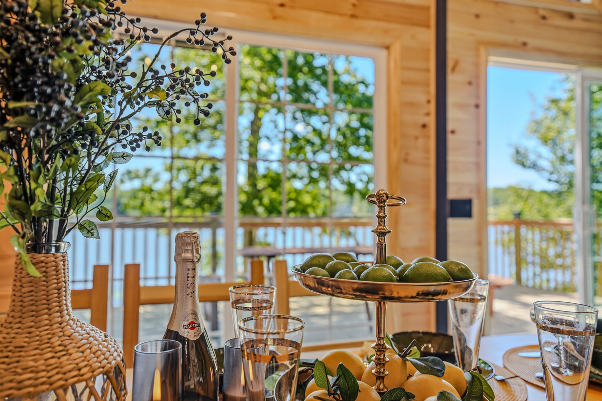 Deck dining setup with champagne, fruit centerpiece, and Lake Carobeth as the backdrop