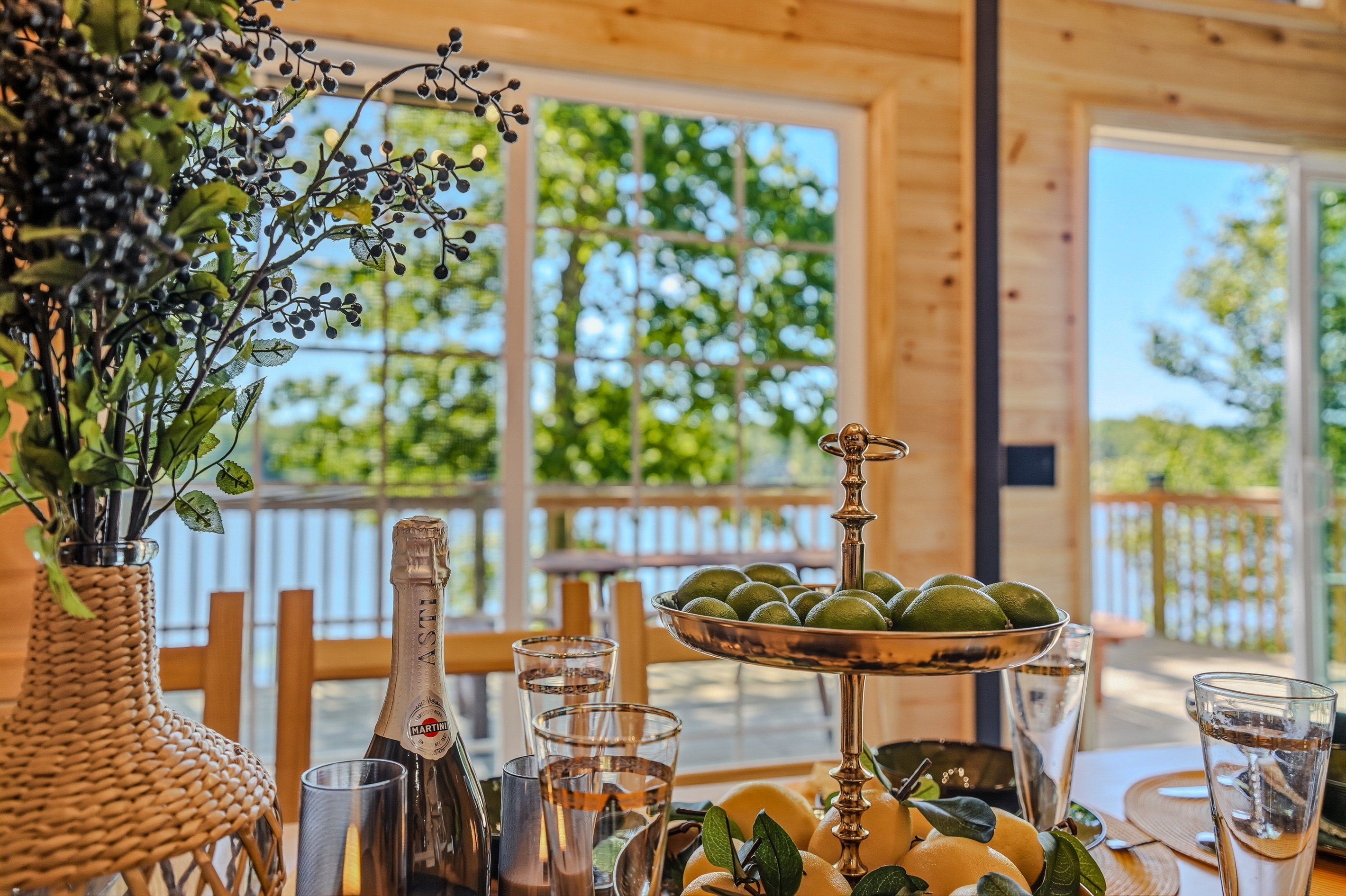Deck dining setup with champagne, fruit centerpiece, and Lake Carobeth as the backdrop
