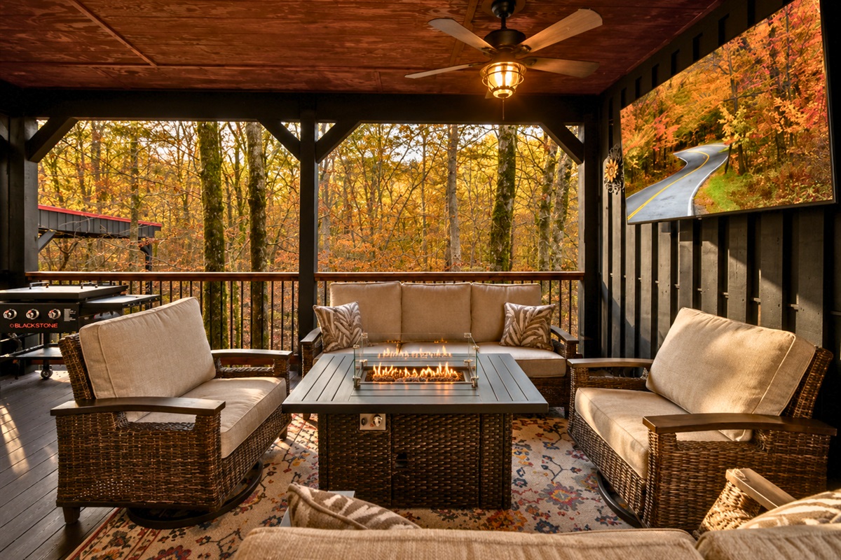 An outdoor fireplace and cozy lounge area make this covered porch ideal for year-round gatherings and quiet nights outdoors.
