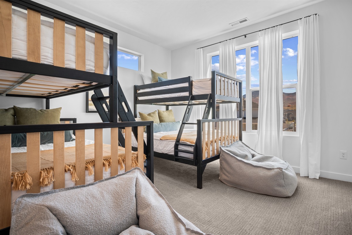 Bright and inviting bunk room featuring cozy beds and mountain views.