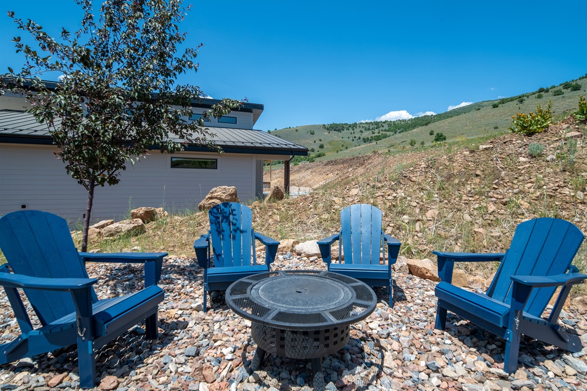 Outdoor fire pit area with Adirondack chairs for evenings under the stars