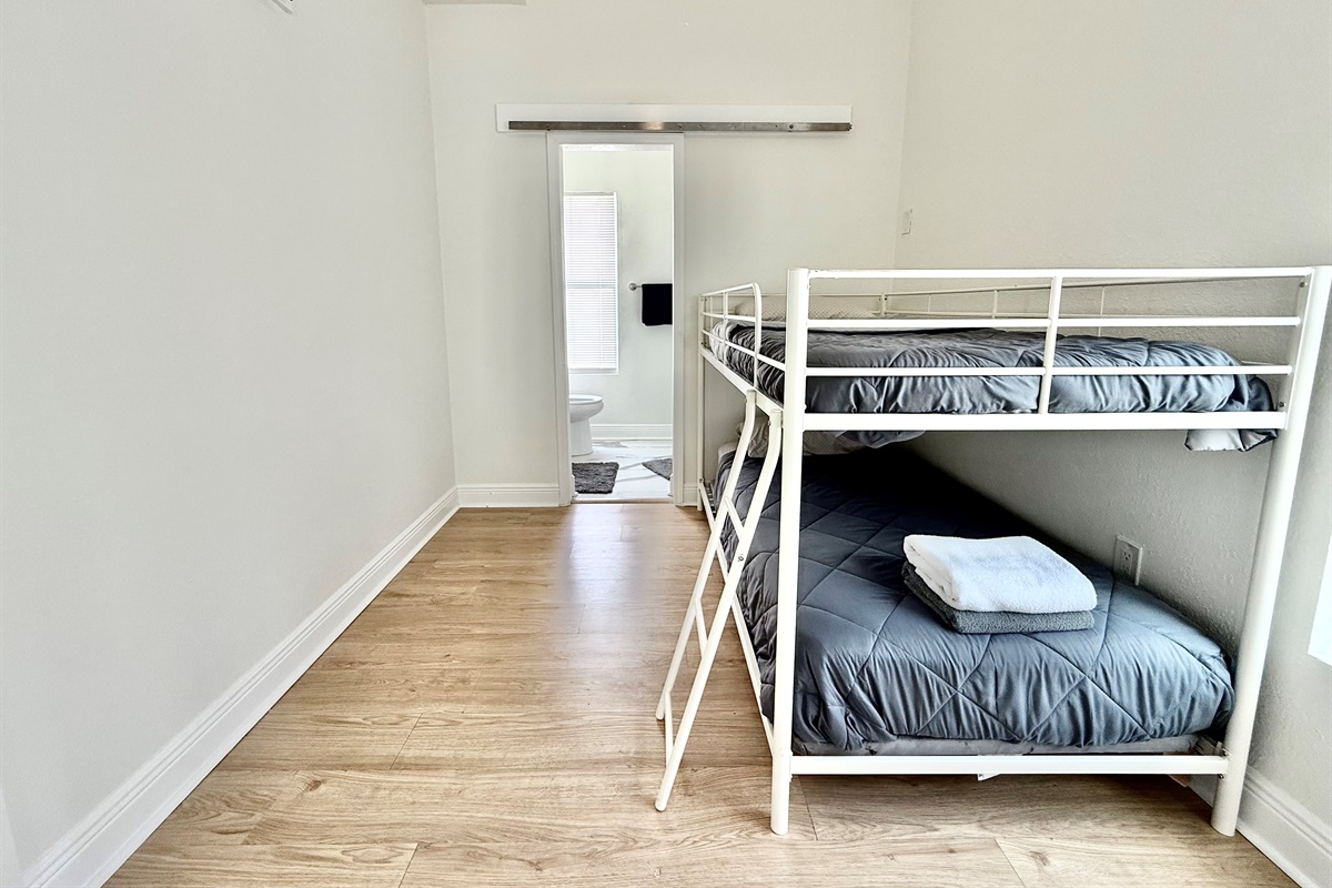 Fun and functional, this bunk room is ideal for kids or teens—complete with natural light and easy access to a modern bathroom.